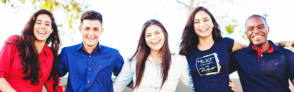 肩をくみ合い笑顔でポーズをとる5人のネイティブ大学生写真